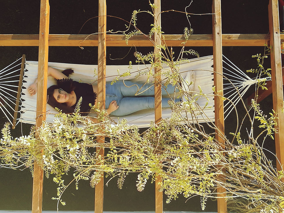 Women relaxing underneath wooden pergola on a hammock